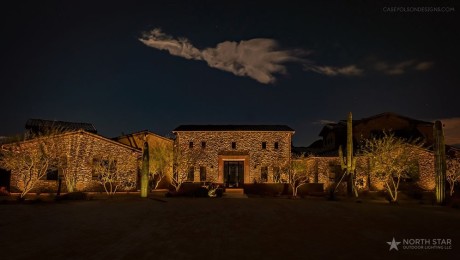 DSCF5814-min Stone estate home lit at night with uplit cactus and a cloud overhead