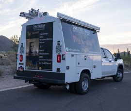 Rear of a North Star Outdoor Lighting service truck showing the services graphic panel