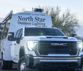 Front view of a North Star Outdoor Lighting GMC service truck with headlights on