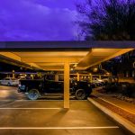 Lit covered parking structure at an apartment community at dusk
