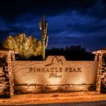 Illuminated Pinnacle Peak Place entry monument sign at night