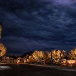 Community entrance and gate lit at night with uplit desert planting