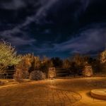 Community entry drive and stone pillars lit at night