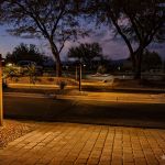 Paver walkway and uplit trees at a golf clubhouse at dusk
