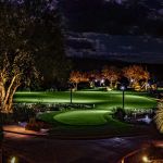 Putting green and desert planting lit at night at a golf clubhouse