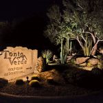 Illuminated Tonto Verde Golf Club entry monument sign with uplit cactus at night