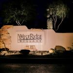 Illuminated West Ridge Village entry monument sign at night
