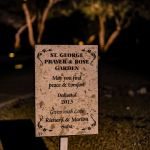 Lit St. George Prayer and Rose Garden dedication sign at night